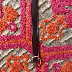 Brown and gold belt with white stitching